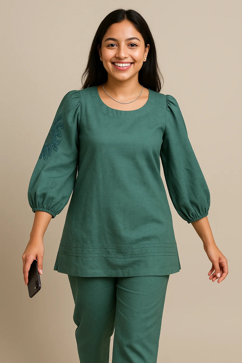 Mul Cotton Pleated Dress with schiffli shoulder detailing, contrast hem and reversible belt.